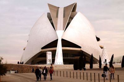 Tourists in front of building against clear sky