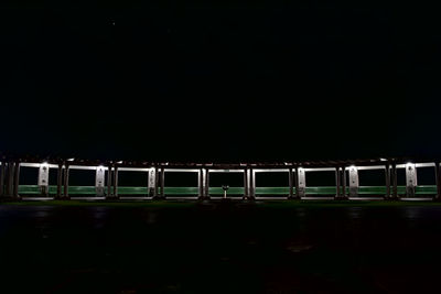 Illuminated bridge against clear sky at night