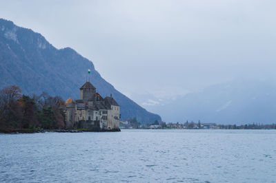 Scenic view of lake by building against sky