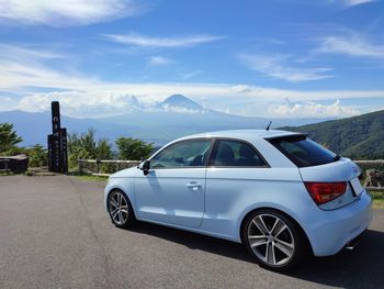 Car on road by mountain against sky