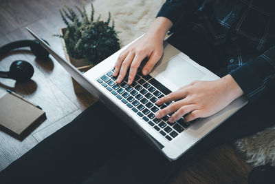 Midsection of man using laptop on table