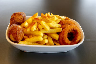 Close-up of burger and fries in plate on table