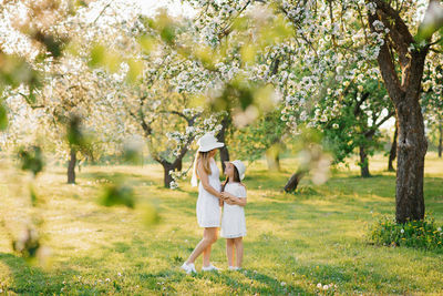 Beautiful and happy mother and daughter in a blooming spring garden. parental love on mother's day.