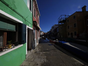 Street amidst buildings against clear sky