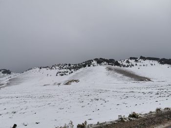 Scenic view of snow covered land against sky