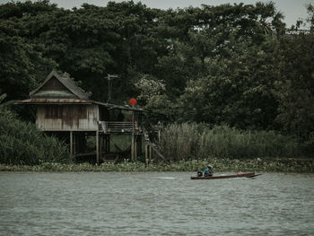 People in river against trees in forest