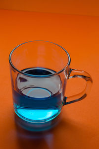 Close-up of orange glass on table