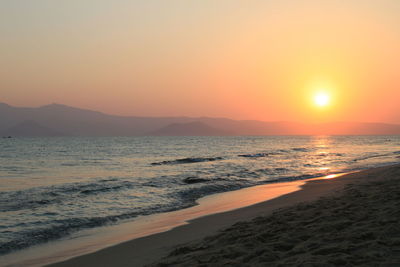 Scenic view of beach against orange sky