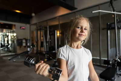 Portrait of smiling girl exercising at gym