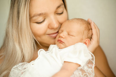 Mother embracing baby at home