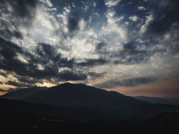 Scenic view of mountains against cloudy sky