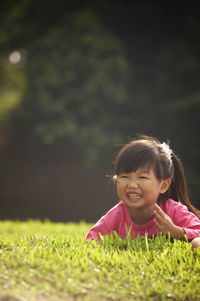 Girl lying on grassy field at park