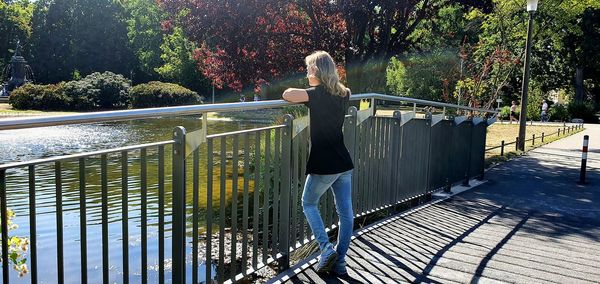 Rear view of woman standing on railing