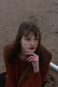 Portrait of young woman lying on land