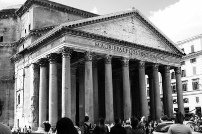 People walking in front of pantheon in city