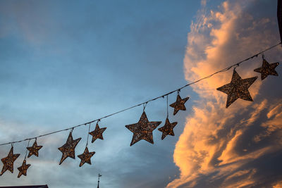 Low angle view of flags hanging against sky