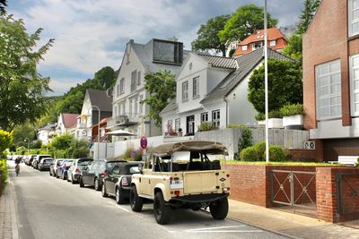 Cars on road by buildings in city