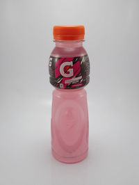 Close-up of pink bottle against white background