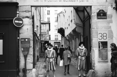 Security guards with people on city street 