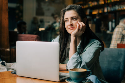 Young woman using laptop at table