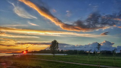 Scenic view of grassy field against cloudy sky