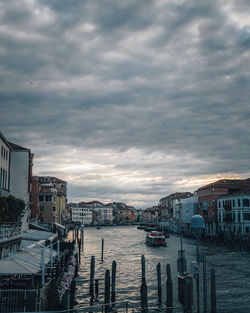 Boats in sea by buildings against sky in city