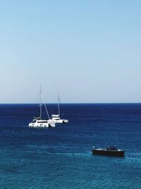 Sailboat sailing on sea against clear sky