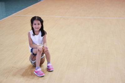 Portrait of a smiling girl sitting on floor