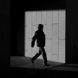 Full length of silhouette man walking against building