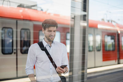 Man standing on train at railroad station