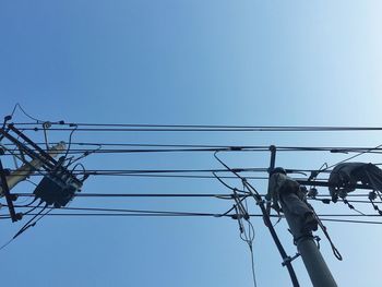 Low angle view of electricity pylon against clear sky