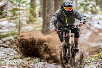 Man riding bicycle on dirt road in forest