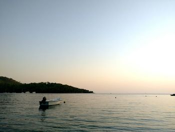 Boat on sea against clear sky during sunset