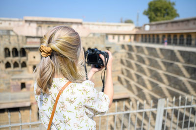 Rear view of woman photographing