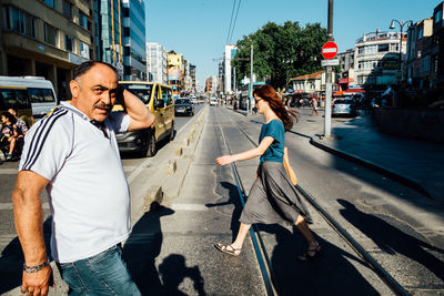 Men walking in city against sky