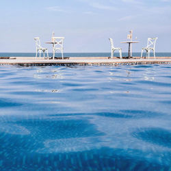 View of swimming pool by sea against sky