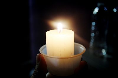 Close-up of lit candle in dark room