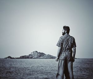 Man looking at sea against clear sky