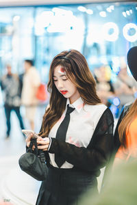 Young woman looking away while standing on floor
