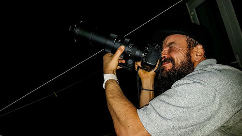 Side view of man photographing at night