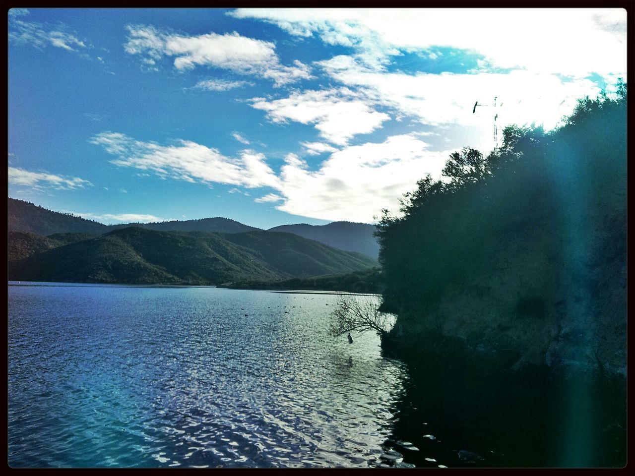 transfer print, water, waterfront, auto post production filter, sky, mountain, tranquil scene, scenics, tranquility, beauty in nature, lake, nature, rippled, cloud - sky, cloud, tree, reflection, river, mountain range, day