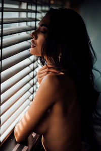 Close-up of seductive woman at window