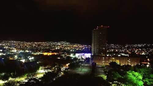 Illuminated buildings in city against sky at night