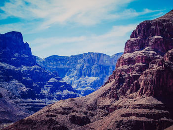 Rocky mountains against cloudy sky on sunny day at grand canyon national park