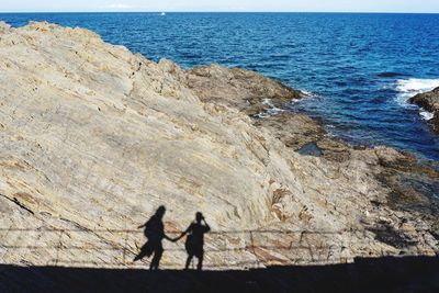 Men on rock at beach