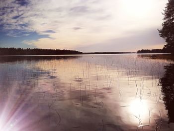 Scenic view of lake against sky at sunset