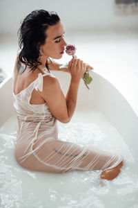 Beautiful woman sitting in bathtub