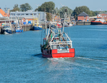 Boat in sea against buildings in city