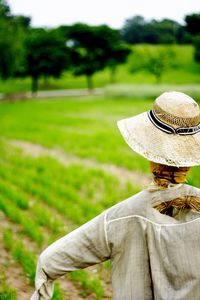 Rear view of woman wearing hat on field