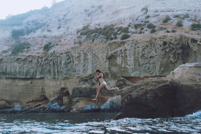 People on cliff by rocky mountains